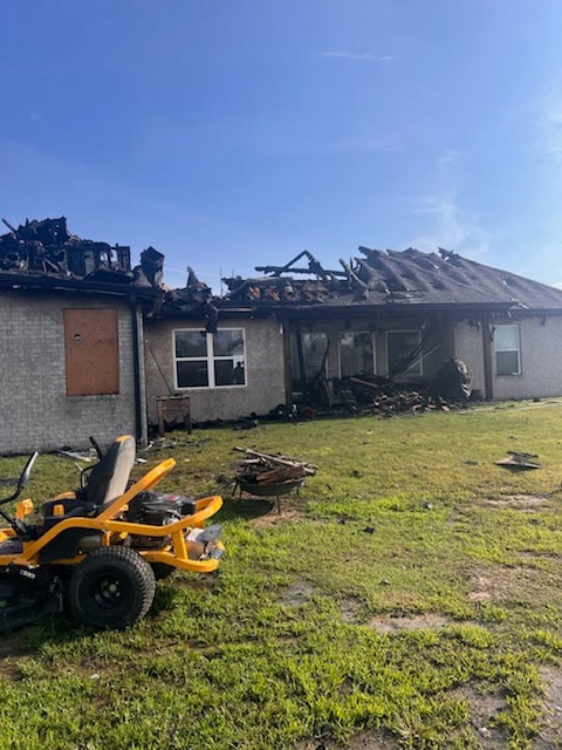 Fire-damaged house in East End, Arkansas with a charred, collapsed roof before demolition by Bratchco