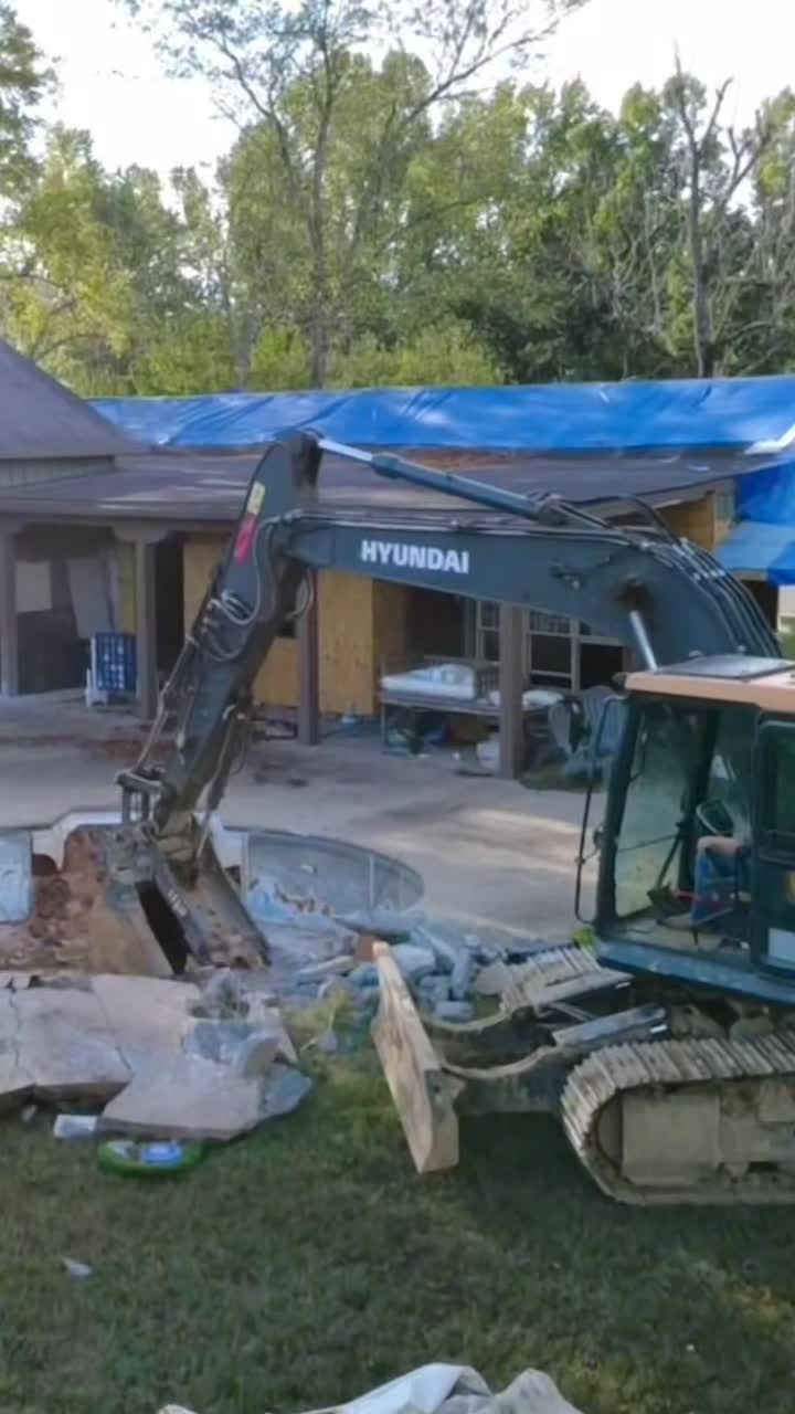 Excavator demolishing a residential swimming pool